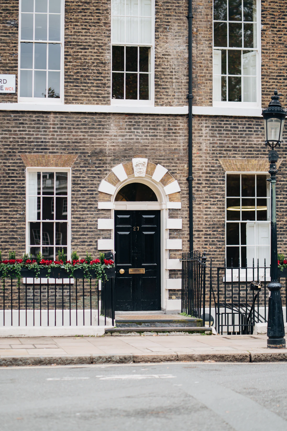 A black front door on a London brick townhouse